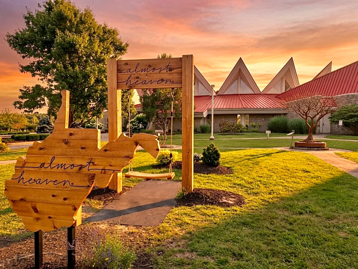 Tamarack arts center at golden hour with the iconic star-peaked roof and "Almost Heaven" West Virginia sign